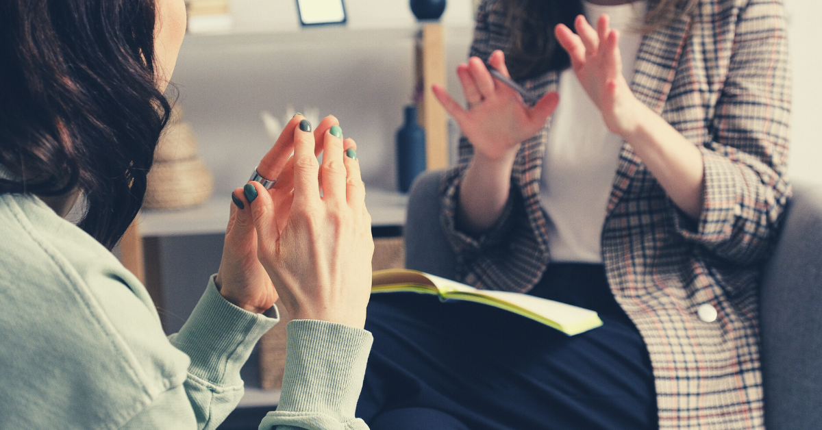 image of two women, one speaking and the other actively listening